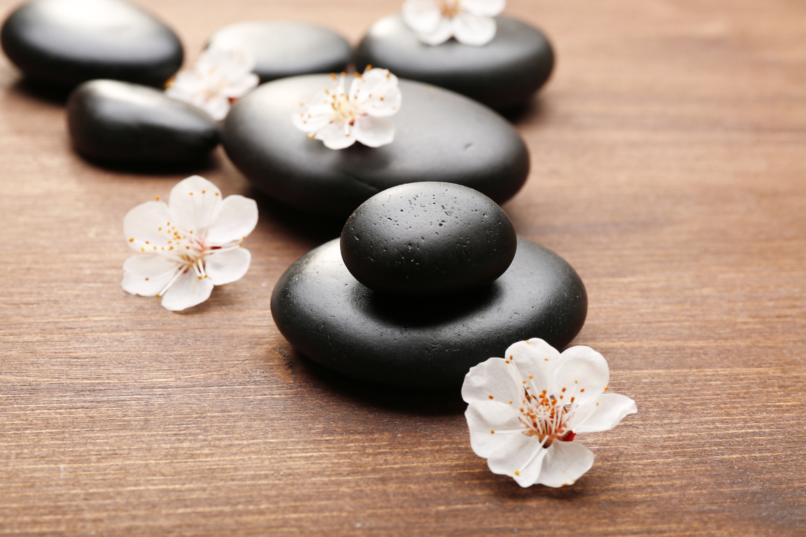 Heap of Spa Hot Stones on Wooden Background